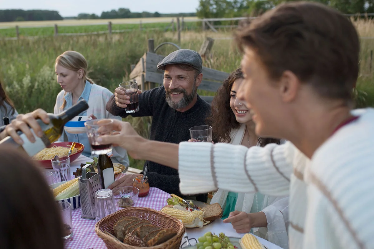 German friends and family drinking red wine and eating