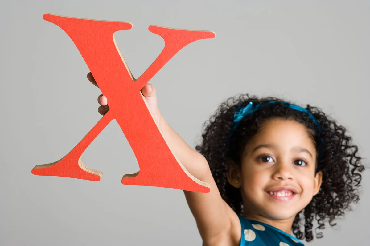Girl holding letter X