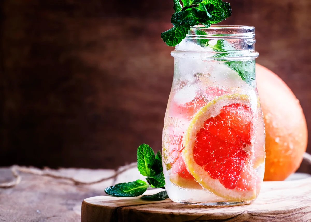 Cold drink with grapefruit, soda, mint and ice