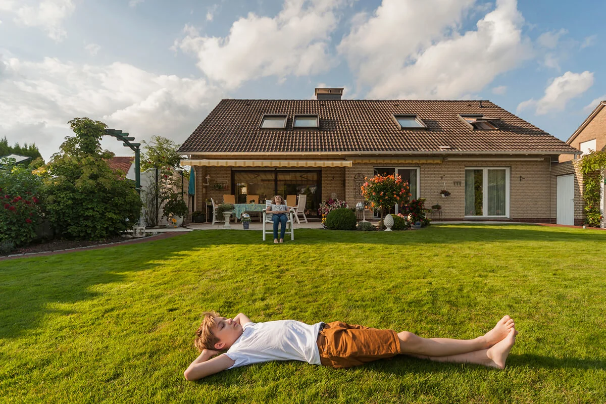 Teenage boy lying in garden