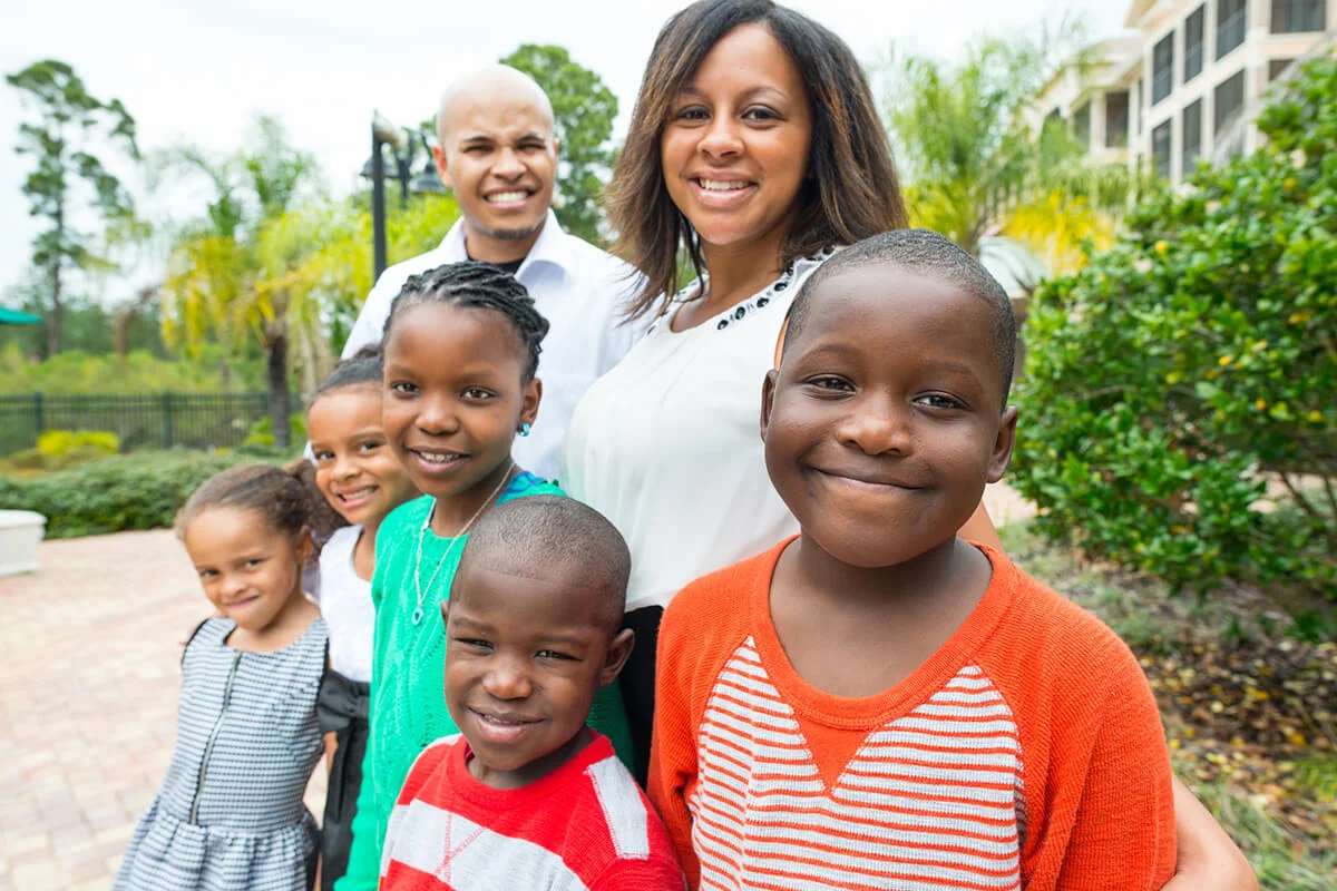 afro caribbean couple posing with their 5 children