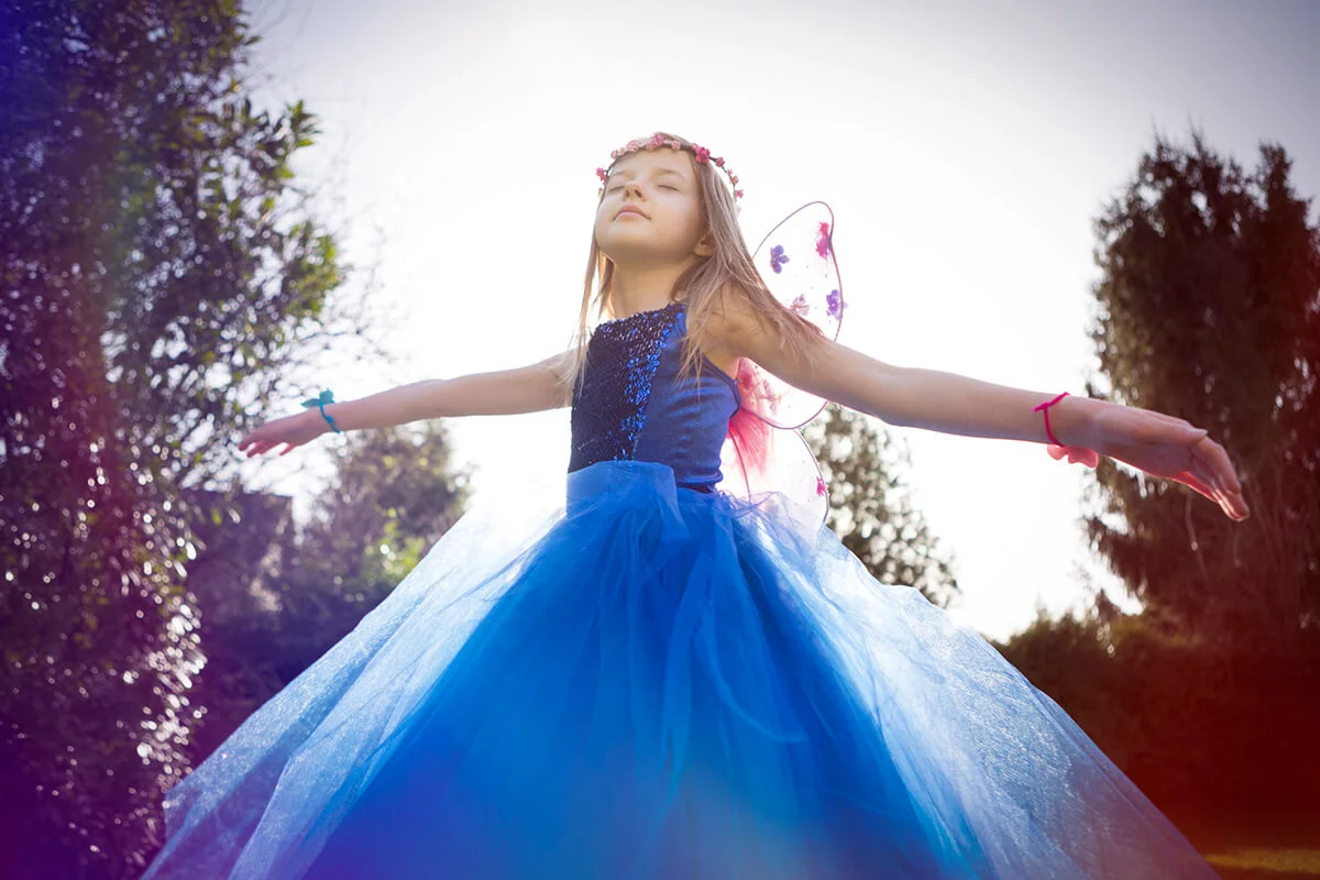 Girl dancing and daydreaming in a blue dress