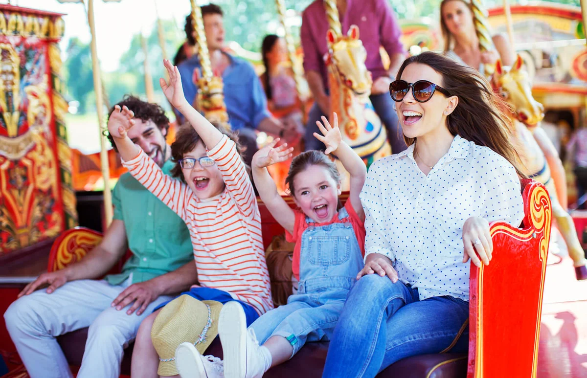 Family on carousel in amusement park