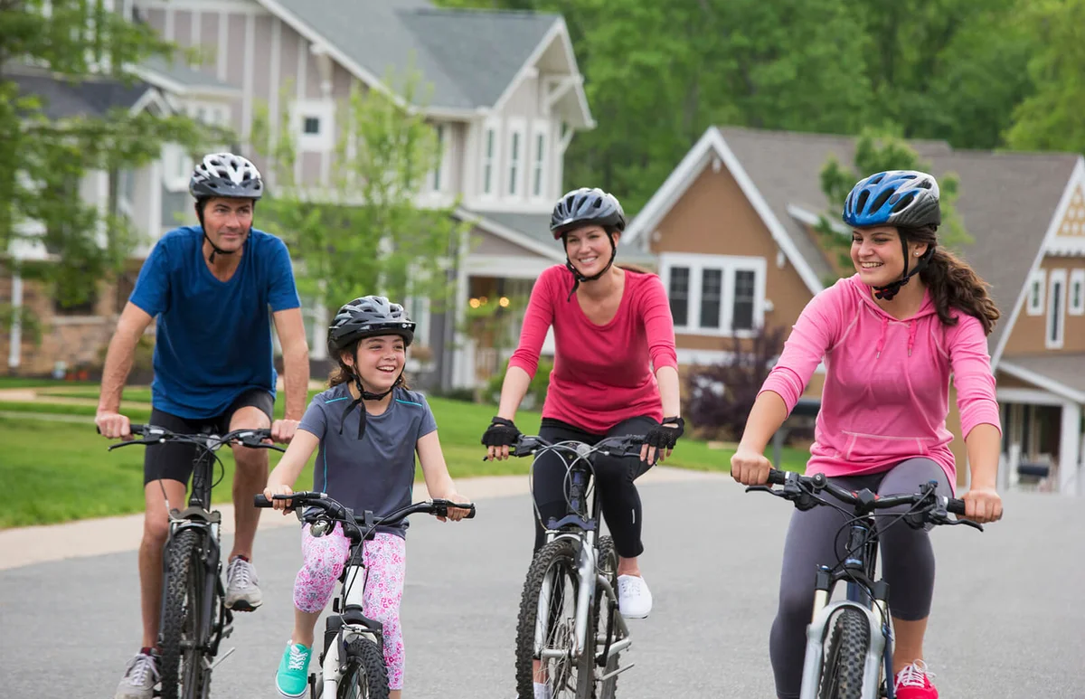Family riding bicycles on suburban street
