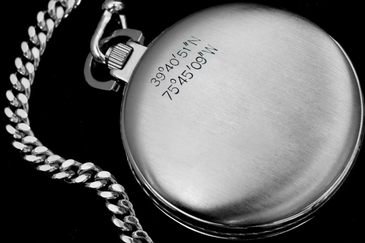 Latitude and Longitude engraved on a watch