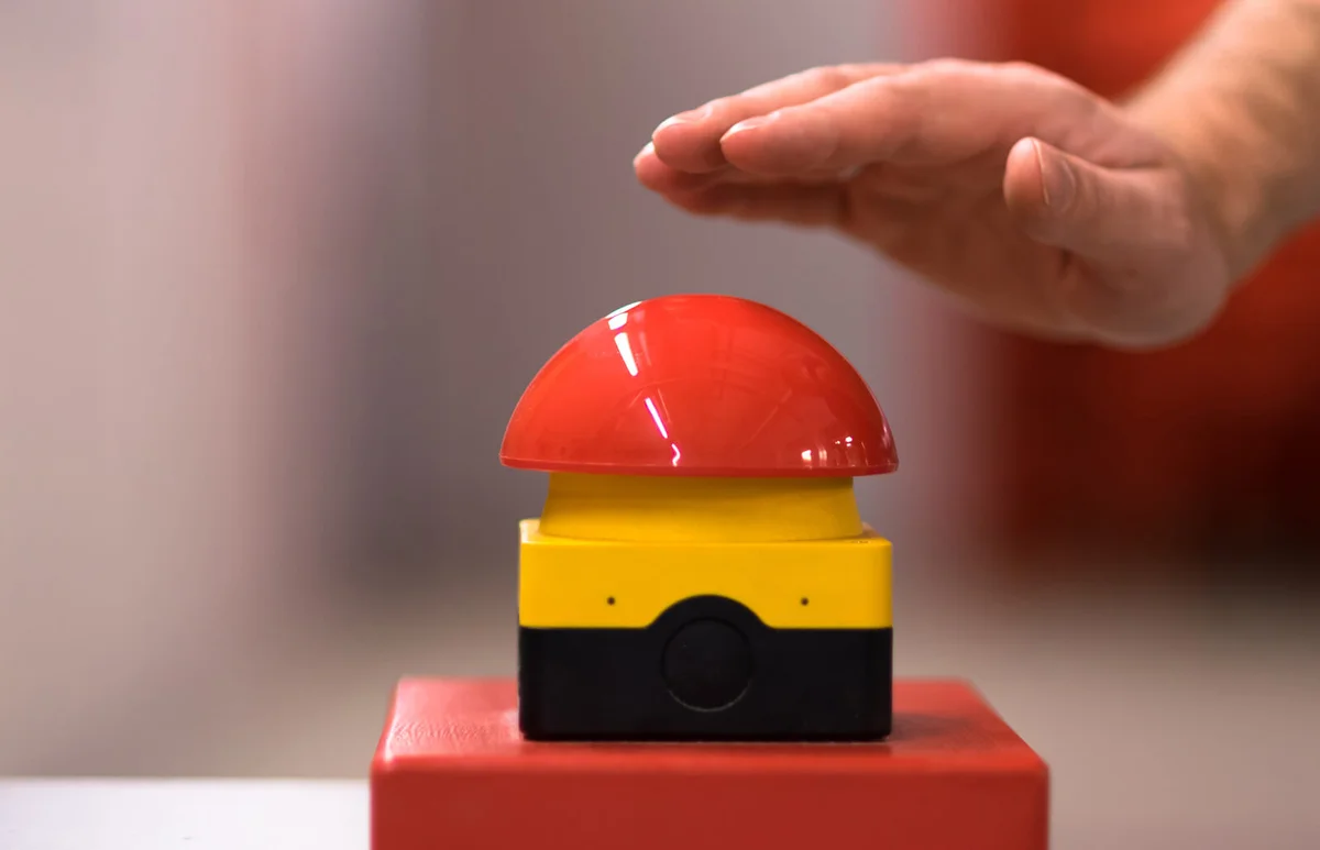 Hand above a red emergency button