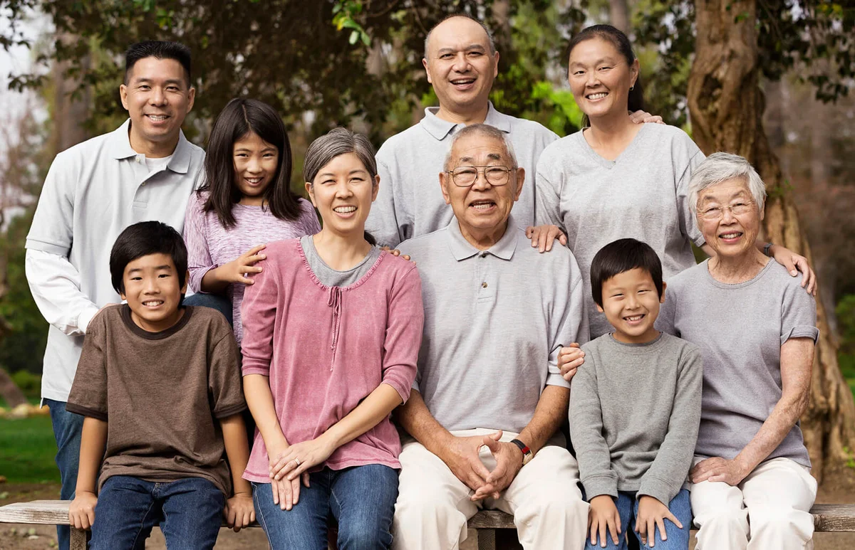 Asian family smiling together outdoors