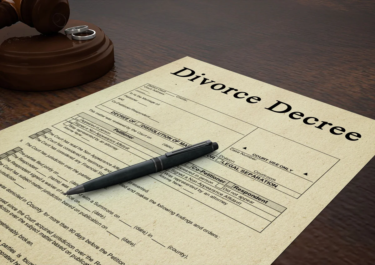 Divorce decree paper with a pen, gavel and rings