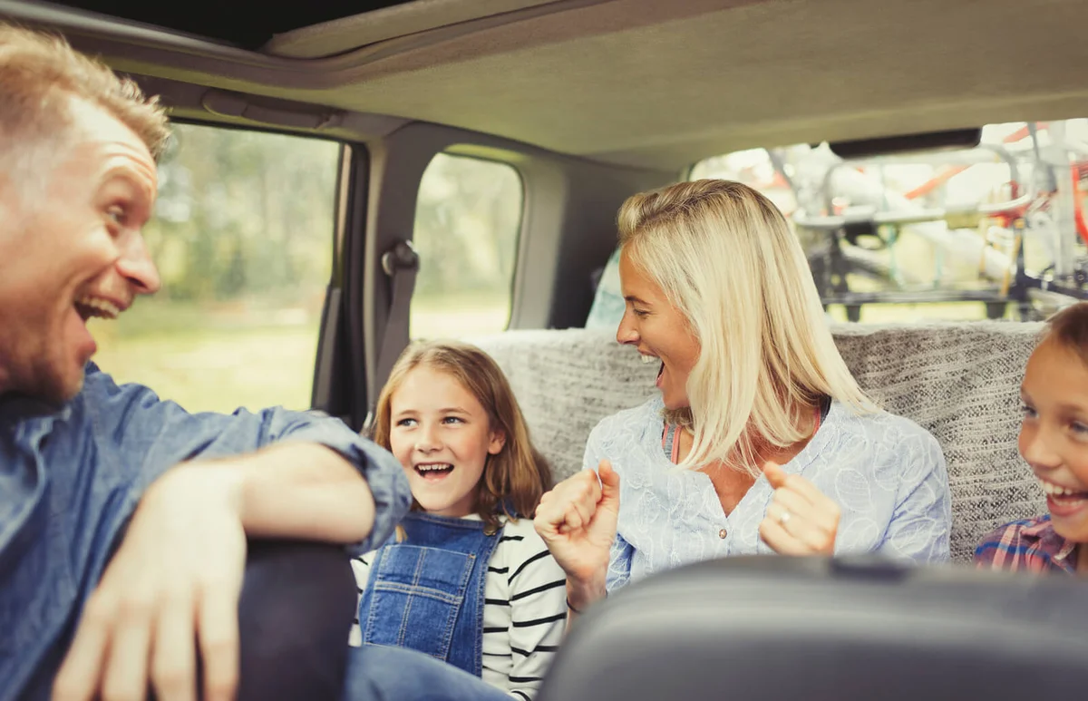 Playful family laughing and singing in car