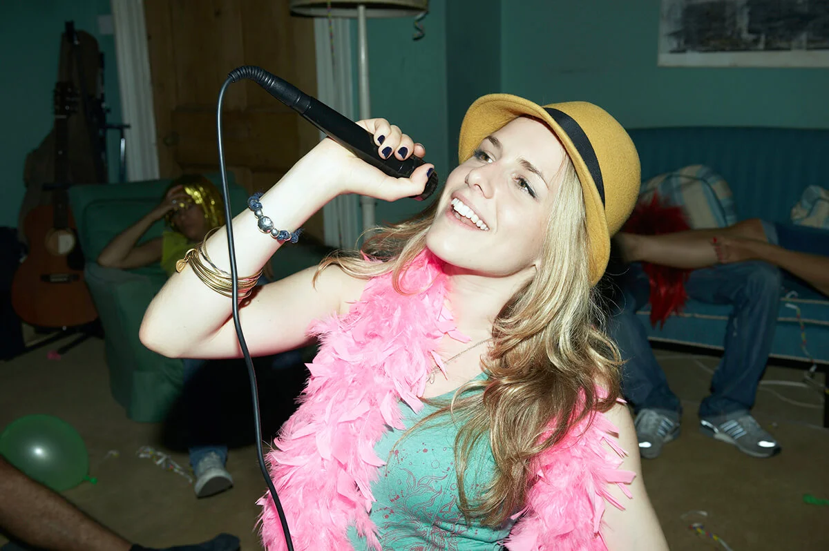Woman singing karaoke at house party