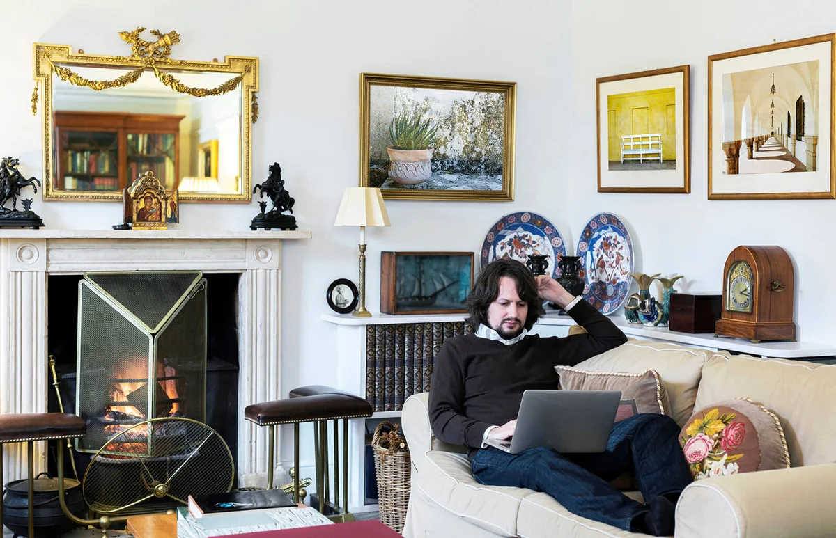 Caucasian man sitting on sofa using laptop