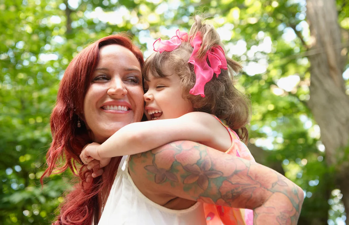 mother carrying daughter piggyback outdoors