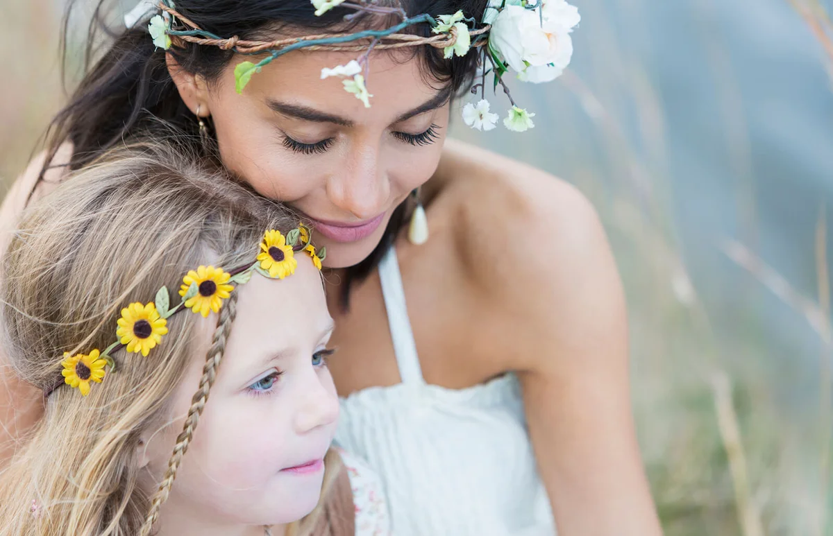 Boho-chic young woman and child sitting by lake