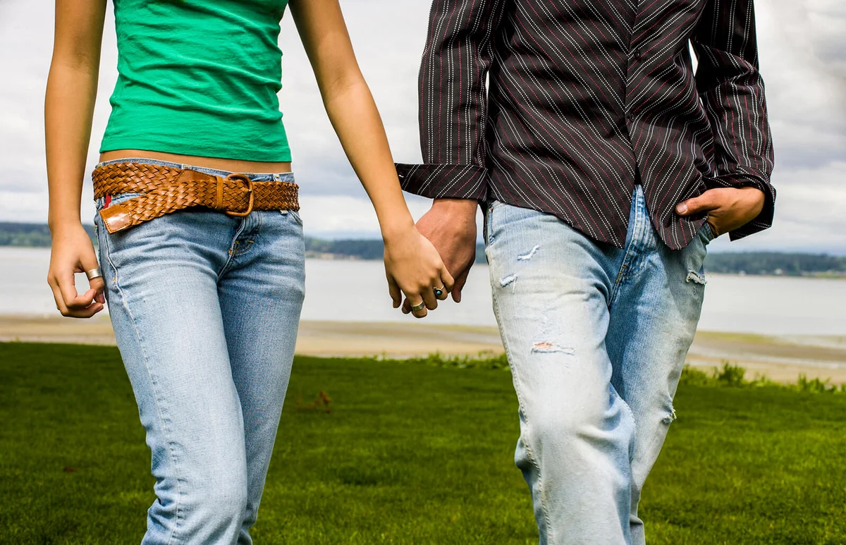 Teenage couple holding hands and walking