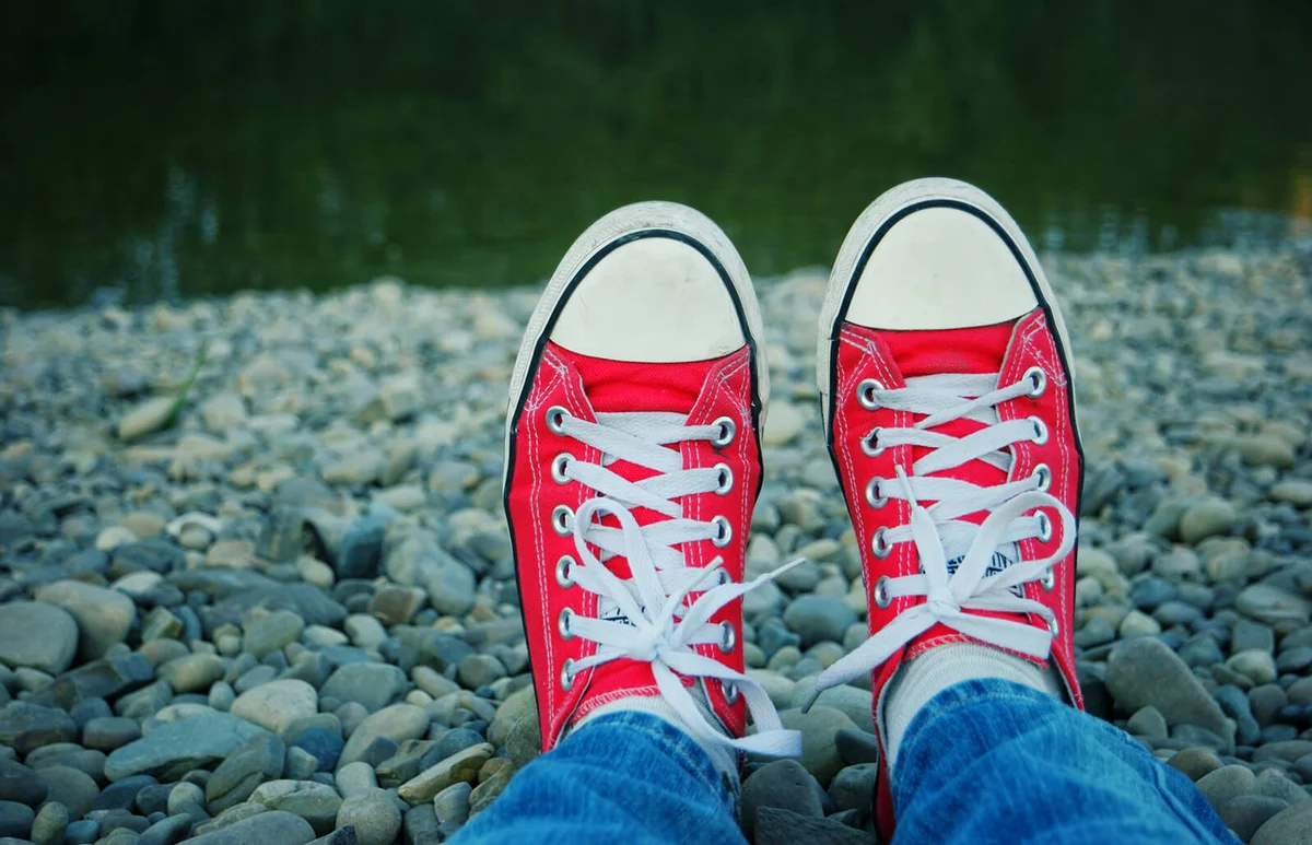 Person Wearing Red Canvas Shoe