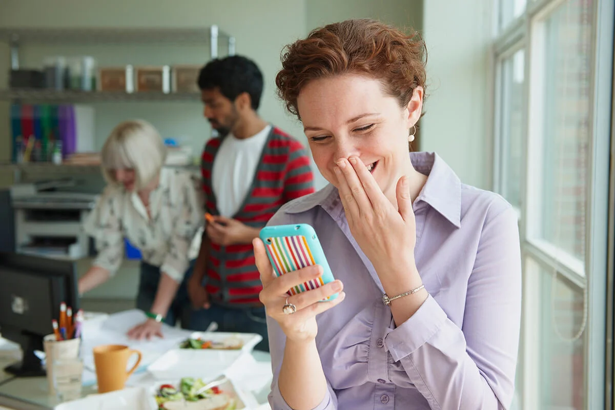Businesswoman laughing at text message