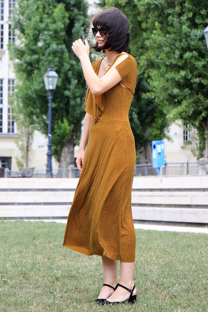 Young Woman Standing On Lawn Against Building