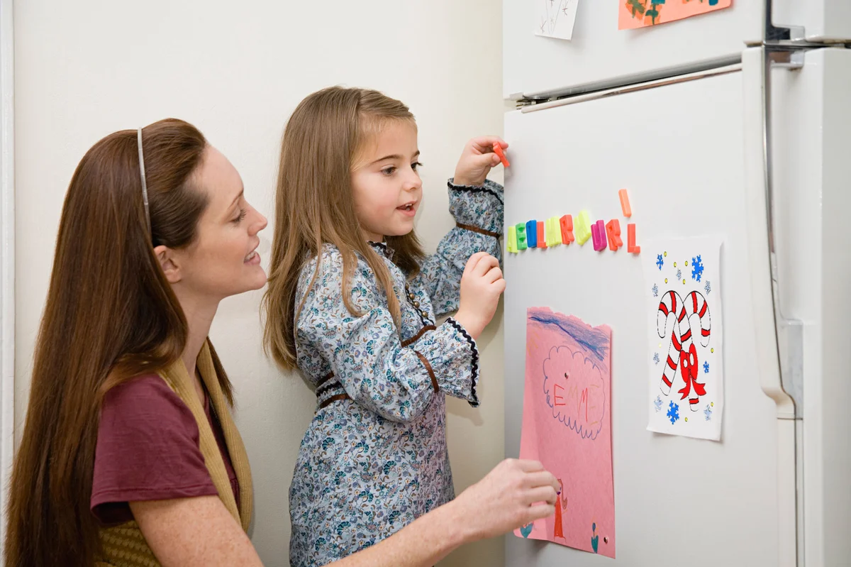 Mother and daughter hanging fridge art
