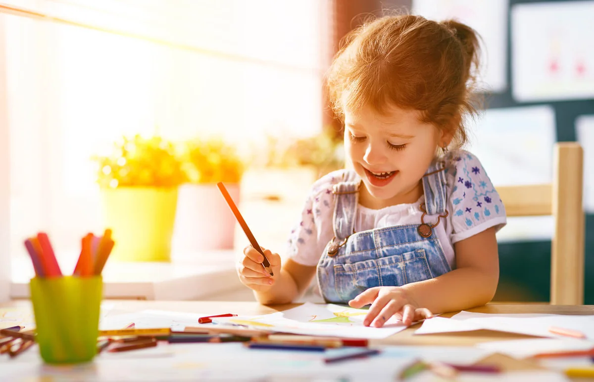 girl draws with colored pencils