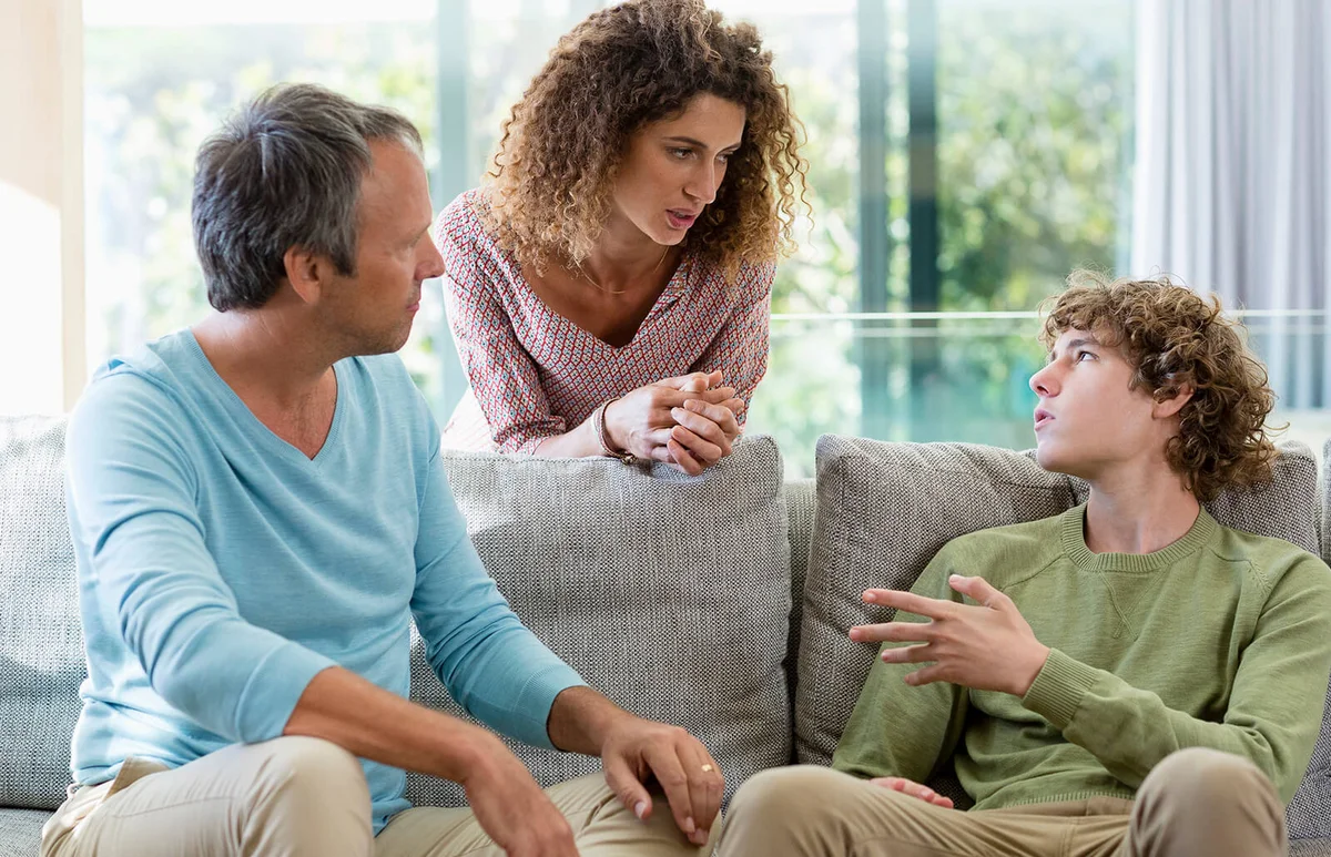Happy family talking in a living room at home