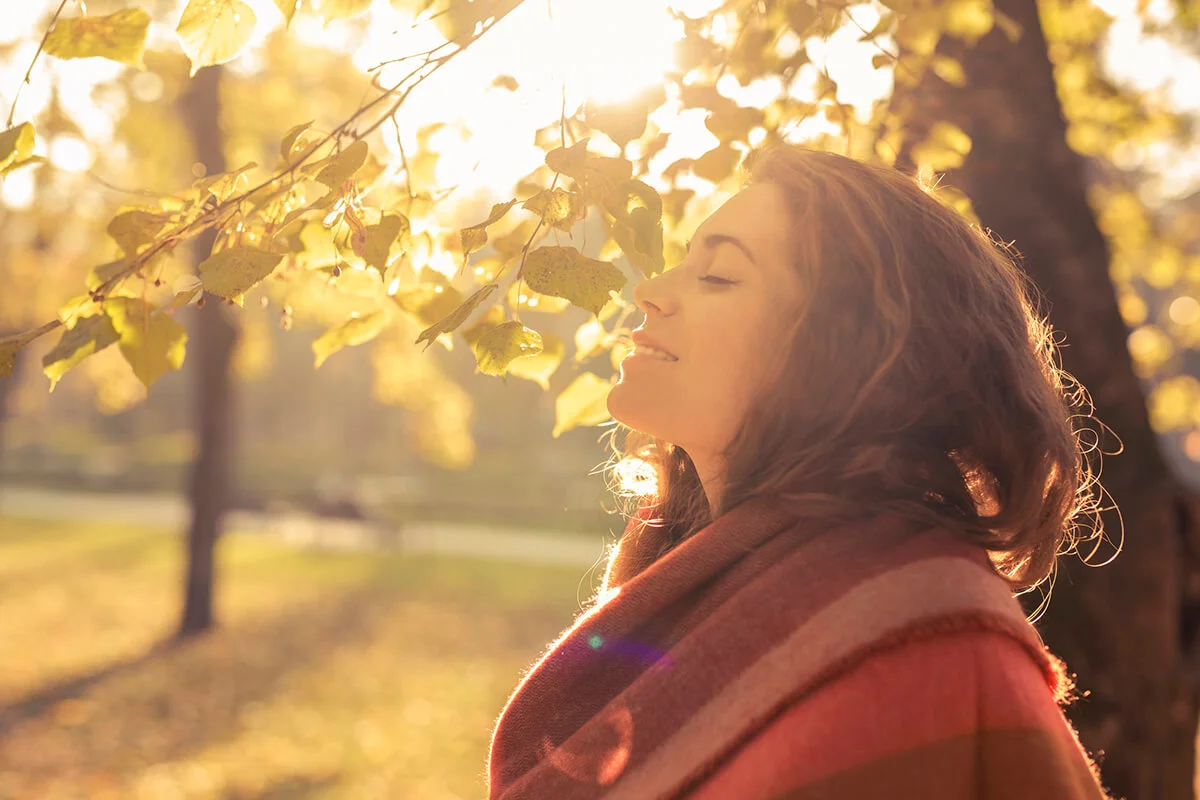 woman standing in the park and enjoying with her eyes closed