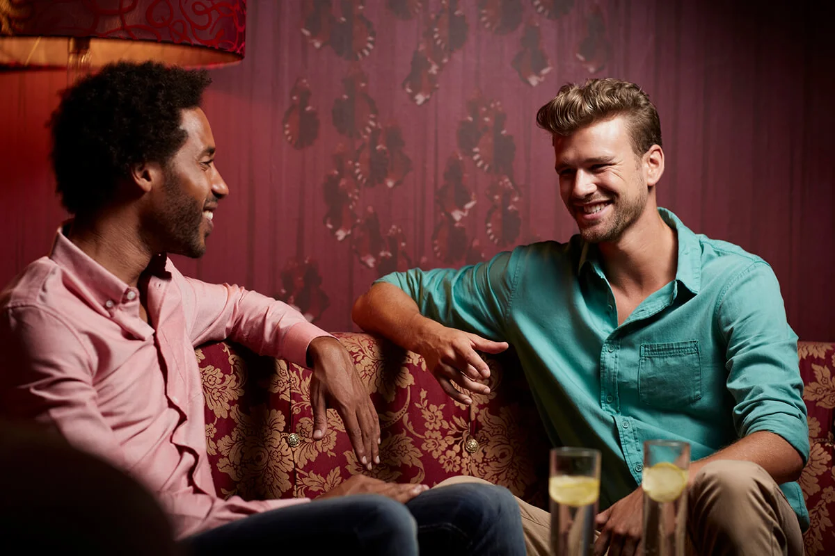 Happy friends communicating on sofa at nightclub