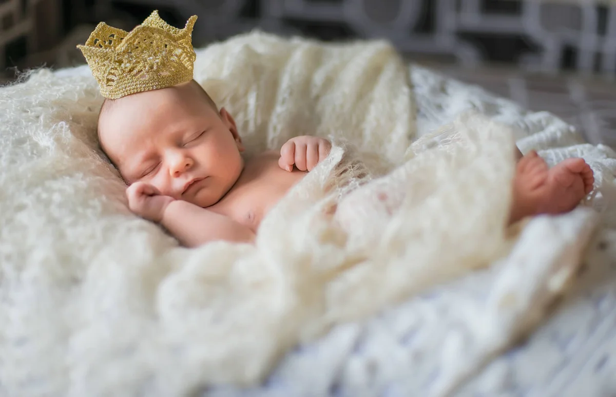 Sleeping newborn baby girl wearing a crown