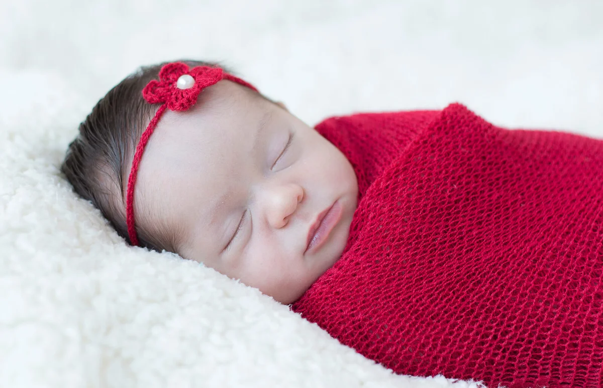 Baby girl wrapped in a blanket sleeping