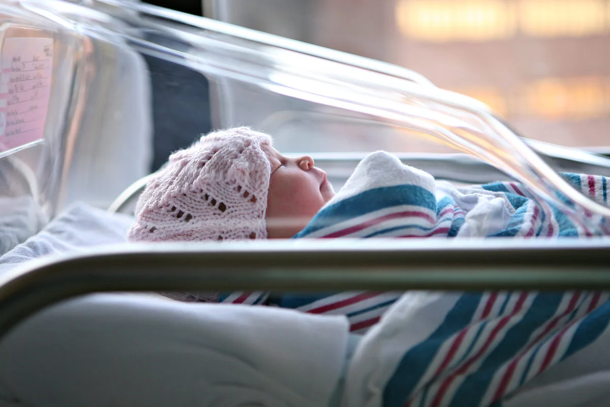 Newborn baby in hospital bassinet