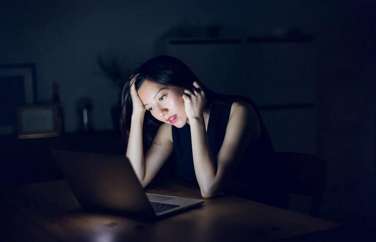 Stressed and frustrated businesswoman working on laptop till late at work