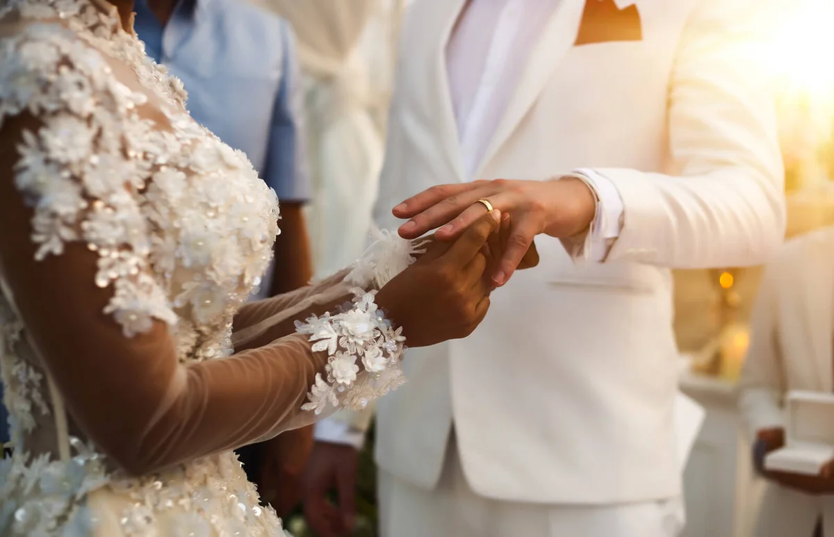 Bride Putting Ring In Groom Finger At Ceremony
