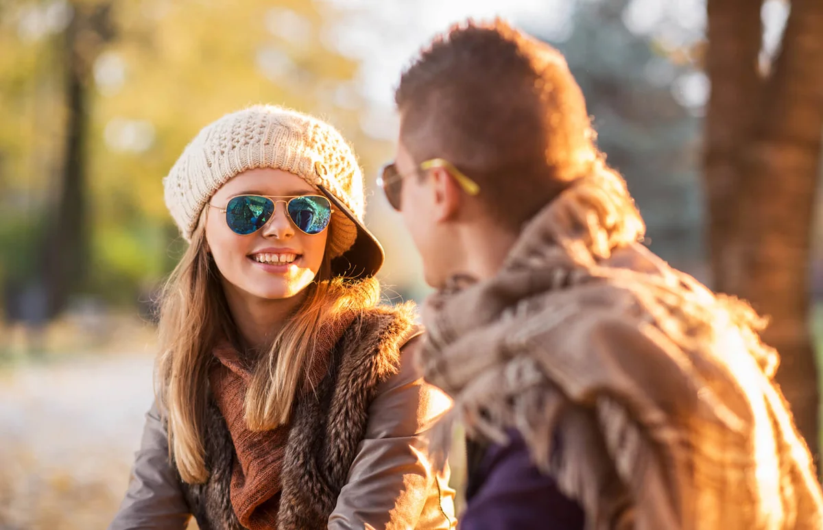 Teenage girl talking to her boyfriend in autumn park