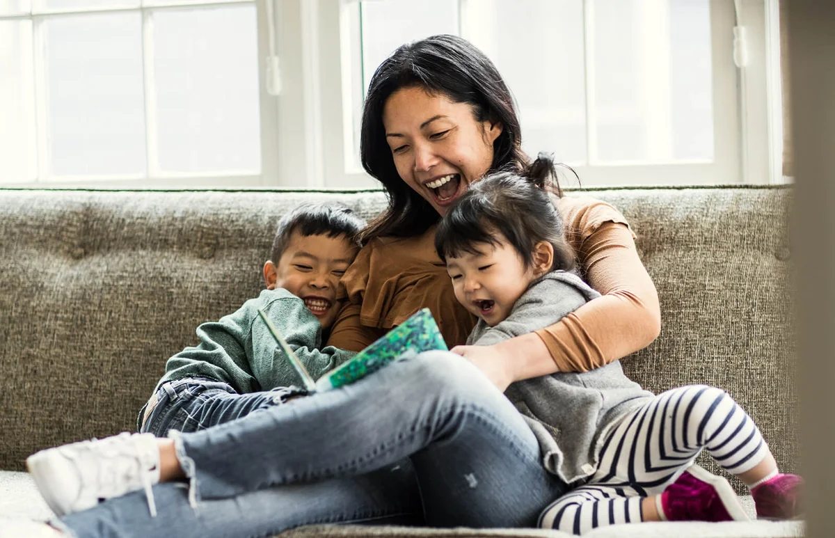 Mother reading to kids on couch