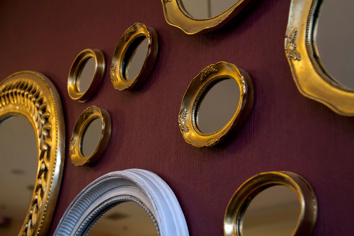 Framed mirrors on wall in various shapes