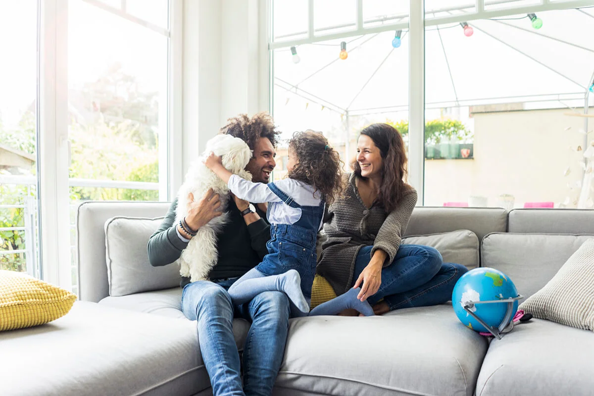 Happy family with dog sitting together in cozy living room