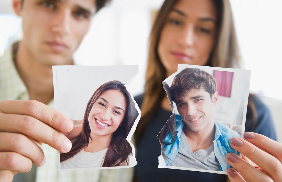 Couple holding torn photograph