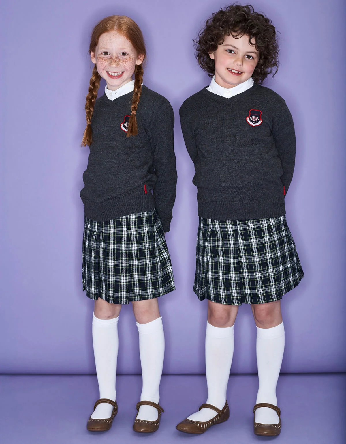two smiling girls wearing school uniform