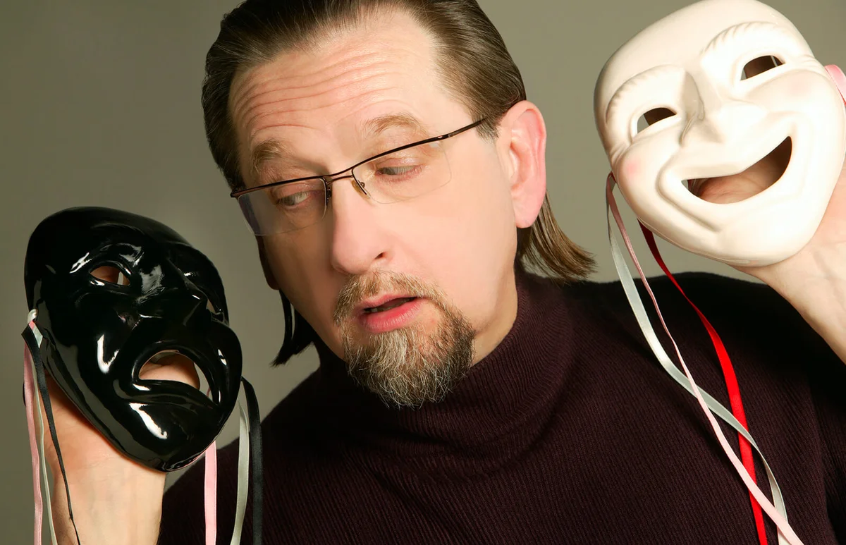 Man holding happy and sad mask