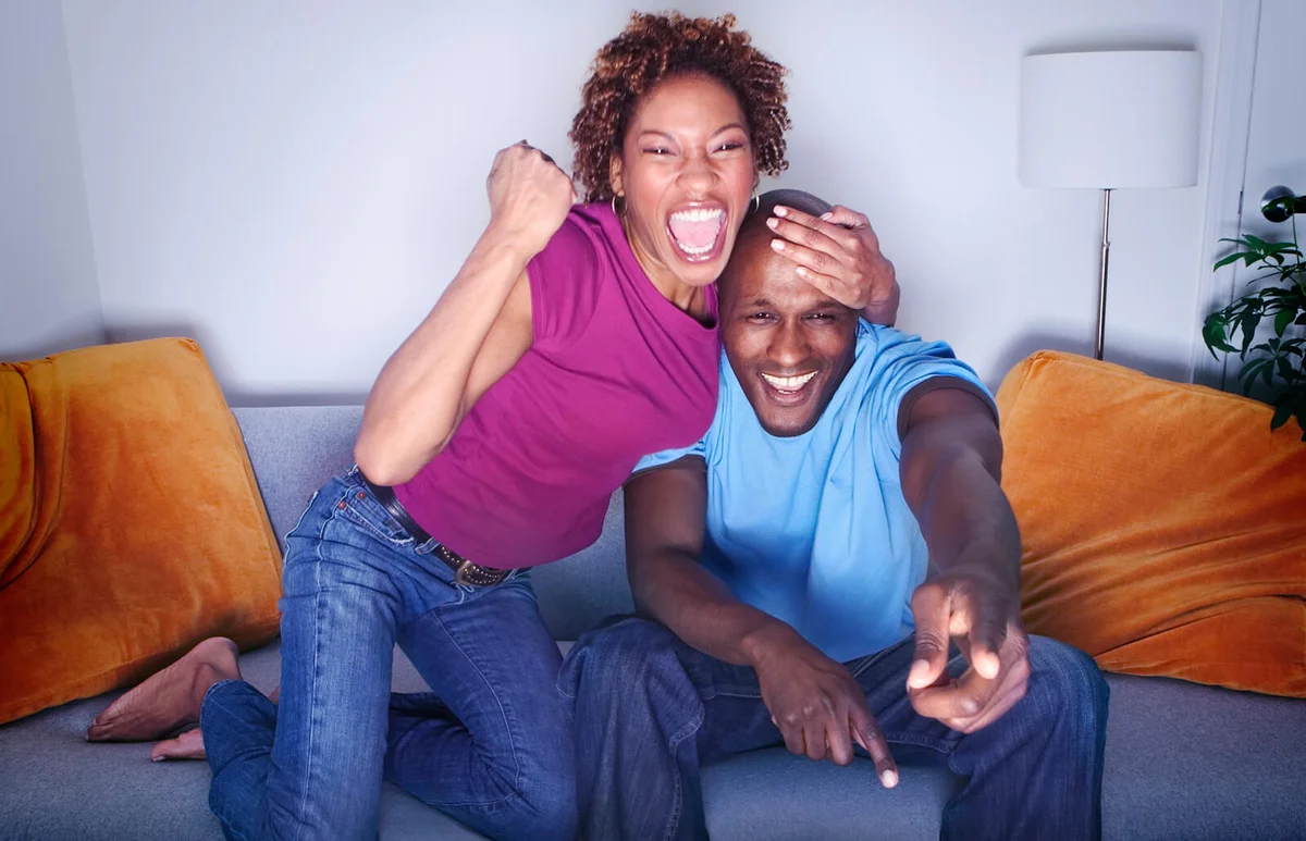 couple cheering on sofa