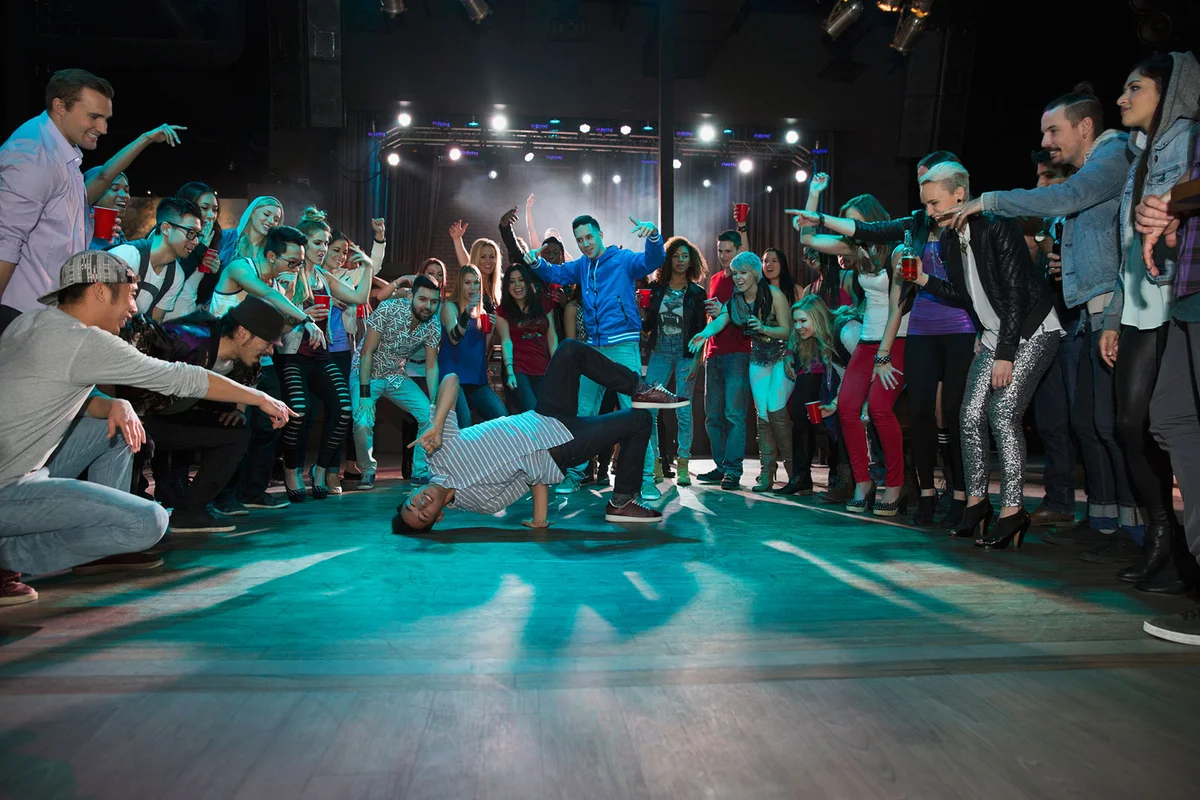 Teens watching and cheering break dancers