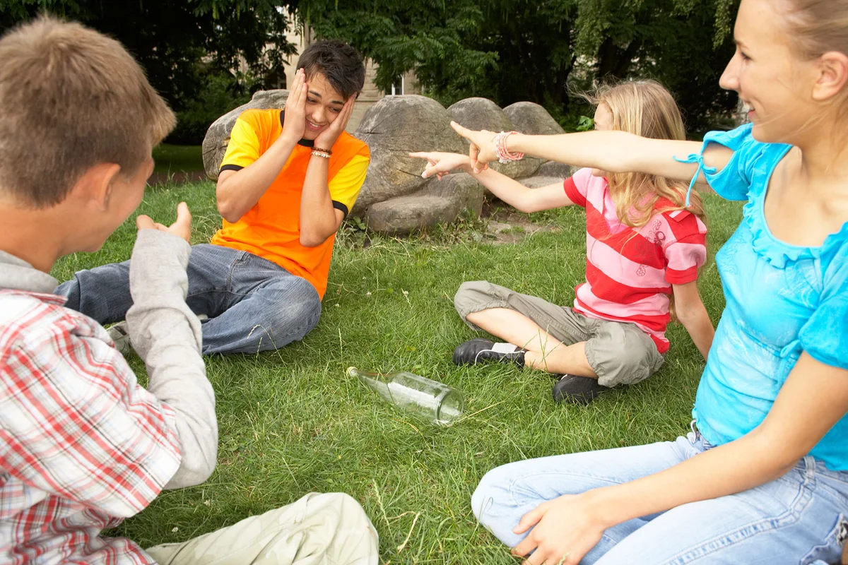 Teens playing bottle game in park