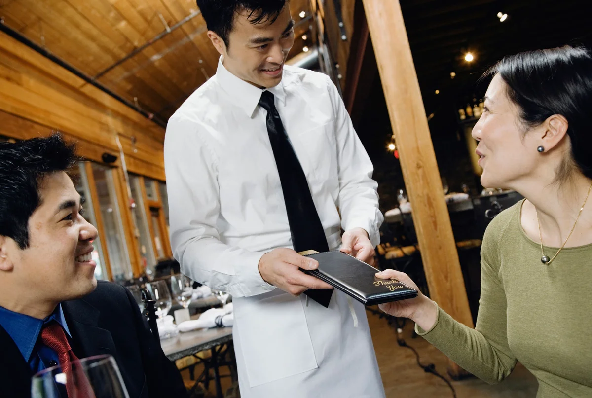 Asian woman paying restaurant bill