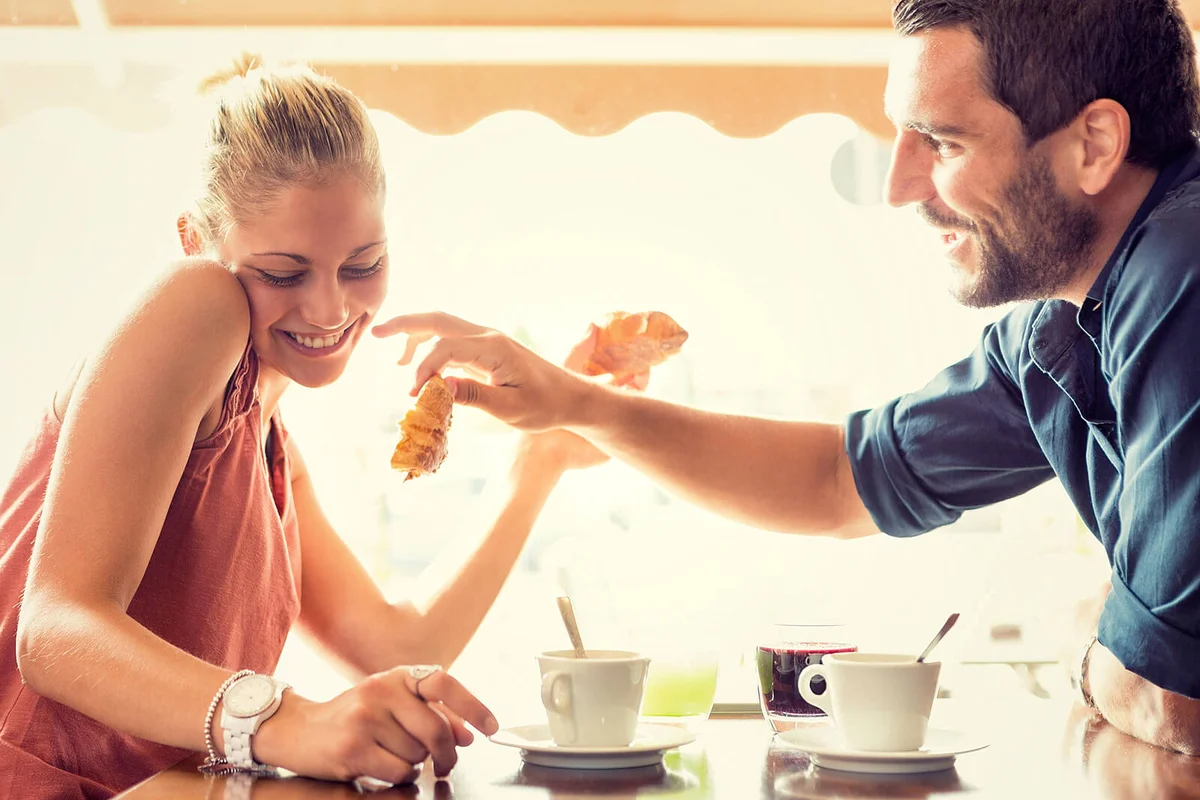 Young couple having breakfast at italian cafe