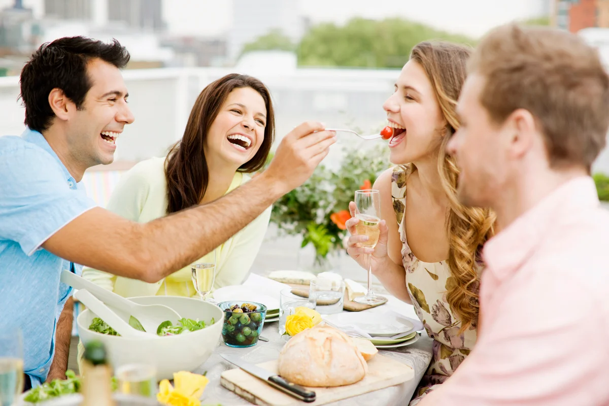 two couples having lunch smiling