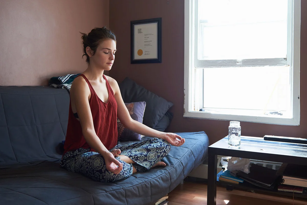 Woman meditating on sofa