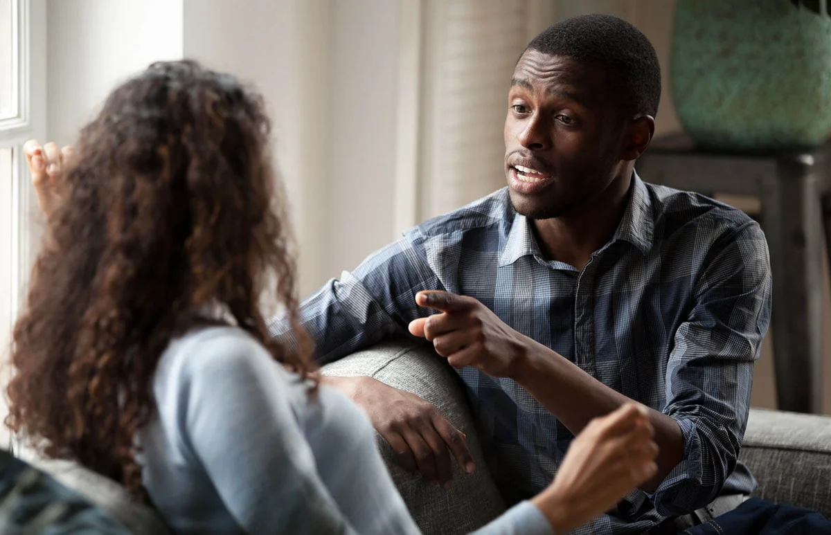 Couple discussing sitting on couch at home