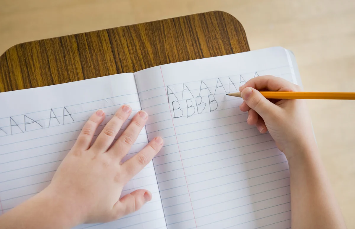 Boy writing letters in classroom