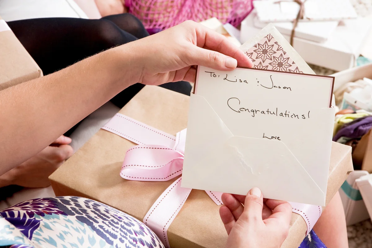 Woman holding up baby shower card