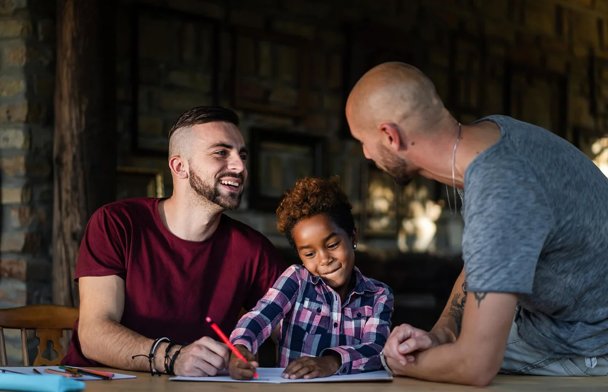 Gay couple spending creative time with their daughter