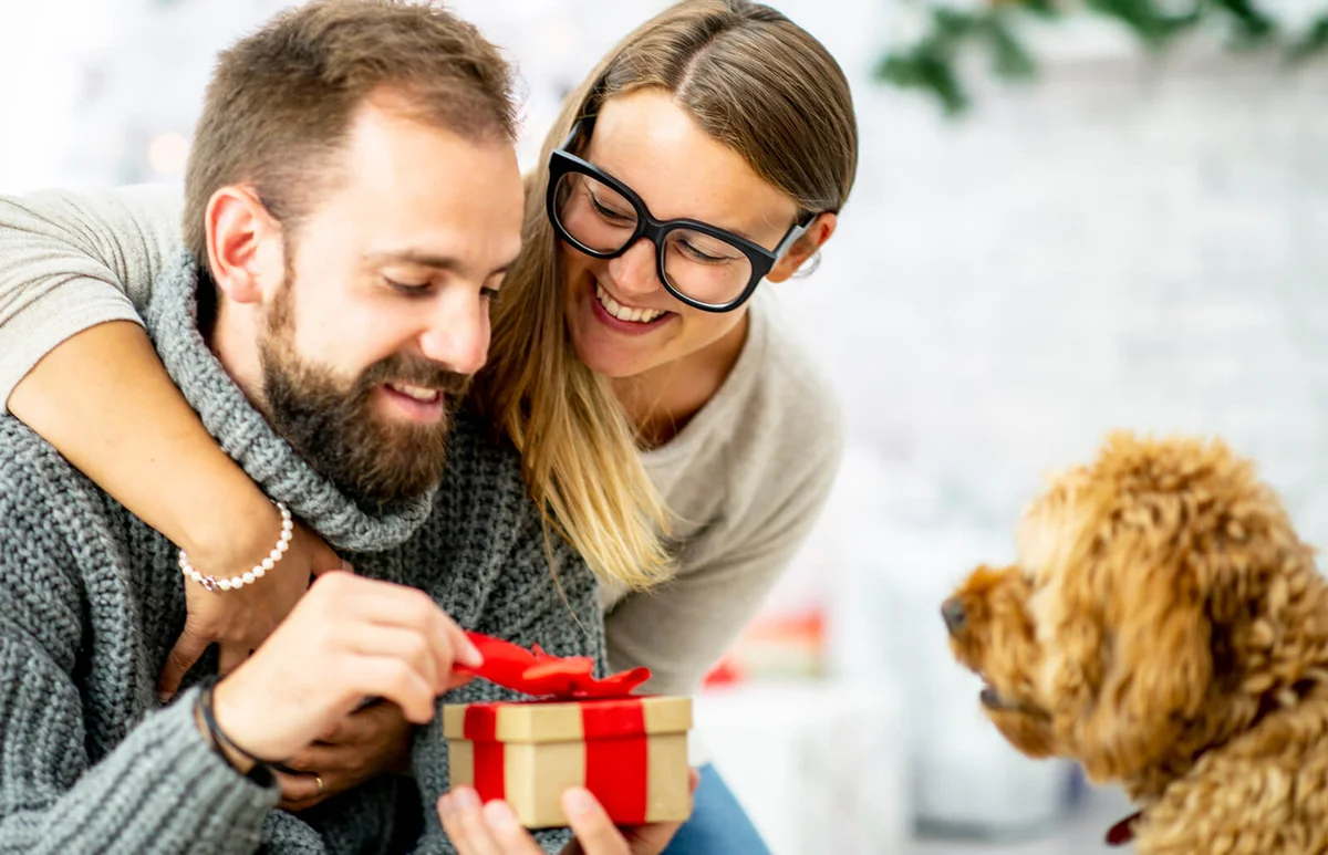 woman gives her partner a wrapped gift